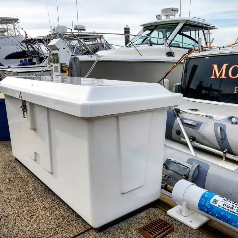 White cooler or storage box on boat deck at Pembroke marina with moored vessels in background.