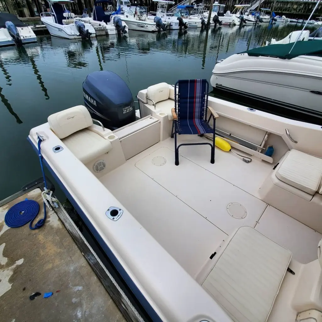Open boat deck with cream seating, Yamaha outboard motor, and moored boats in background at Pembroke marina.