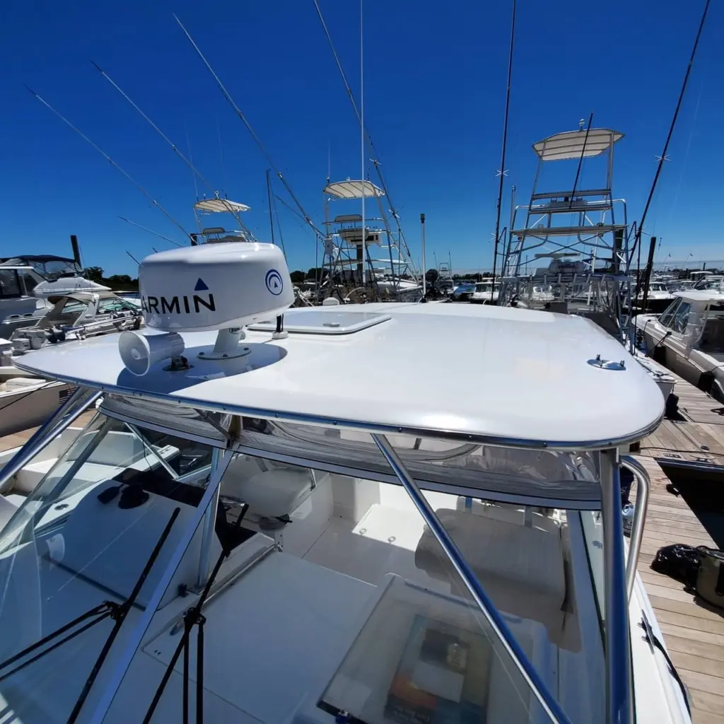 White fiberglass boat with Garmin radar dome mounted on hardtop, docked at Pembroke marina with multiple vessels in background.