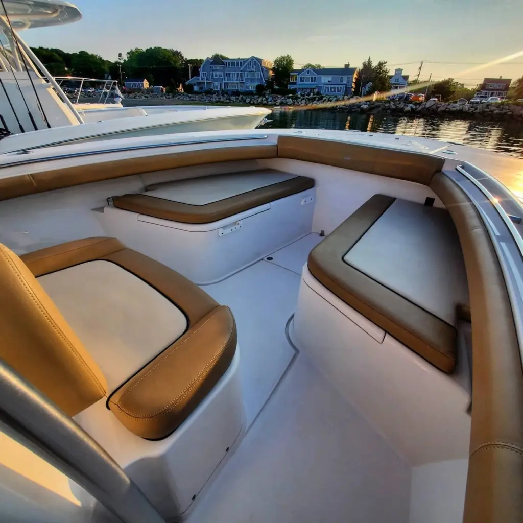 Sun deck with tan leather lounge seating and white cushions on a boat moored in Pembroke.