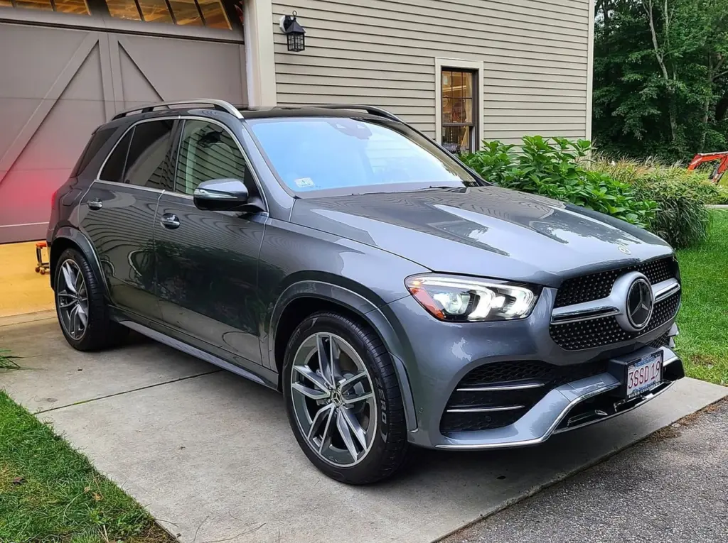 Gray Mercedes-Benz GLE SUV parked on driveway in front of residential home with garage.