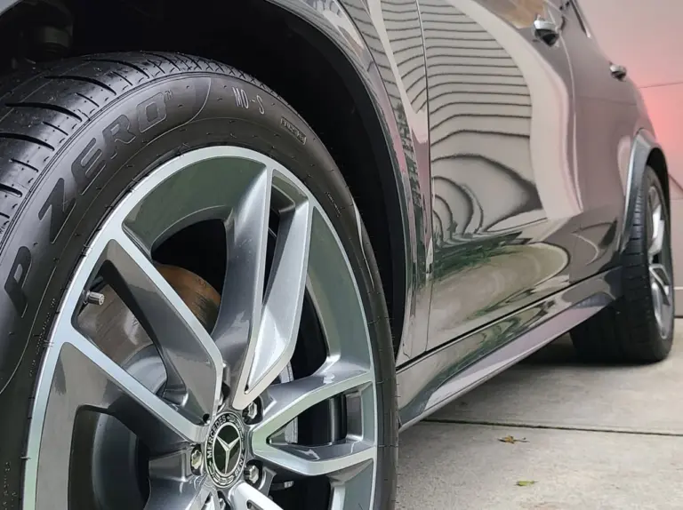 Close-up of a Mercedes-Benz alloy wheel and tire on a silver sedan, showing reflective finish and tread detail.