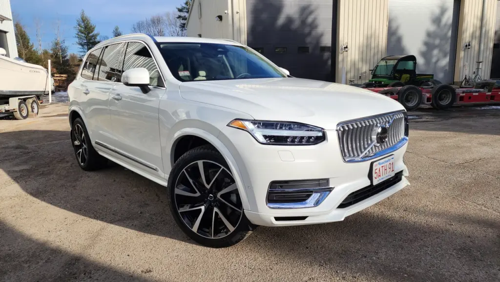White Volvo luxury SUV parked at an angle in a service lot, showing front and driver side.