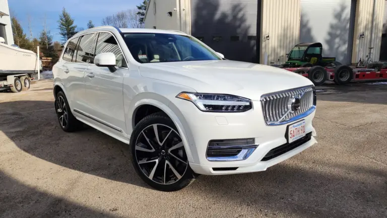 White Volvo luxury SUV parked at an angle in a service lot, showing front and driver side.